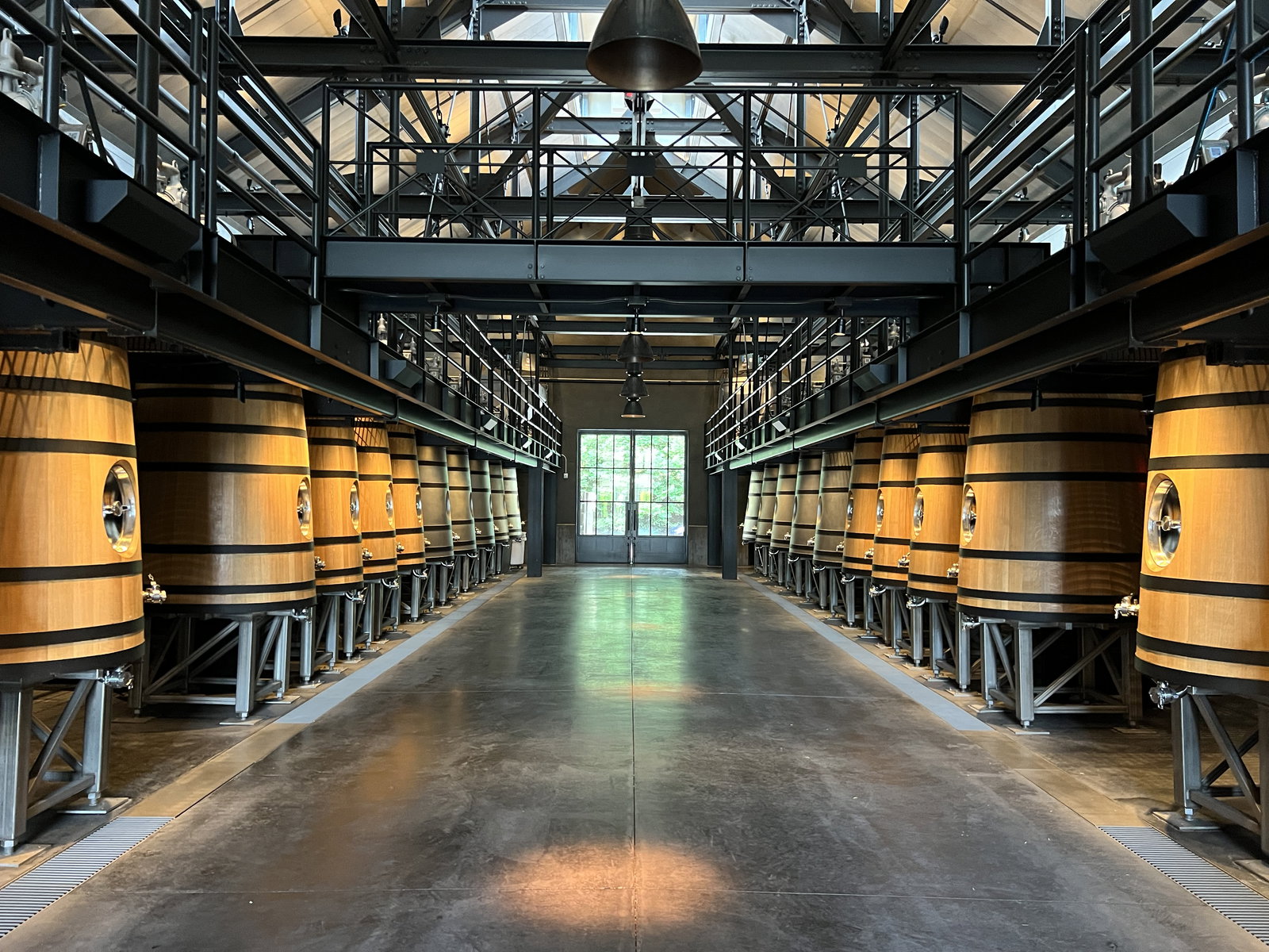 the inside of a winery with big oak barrels