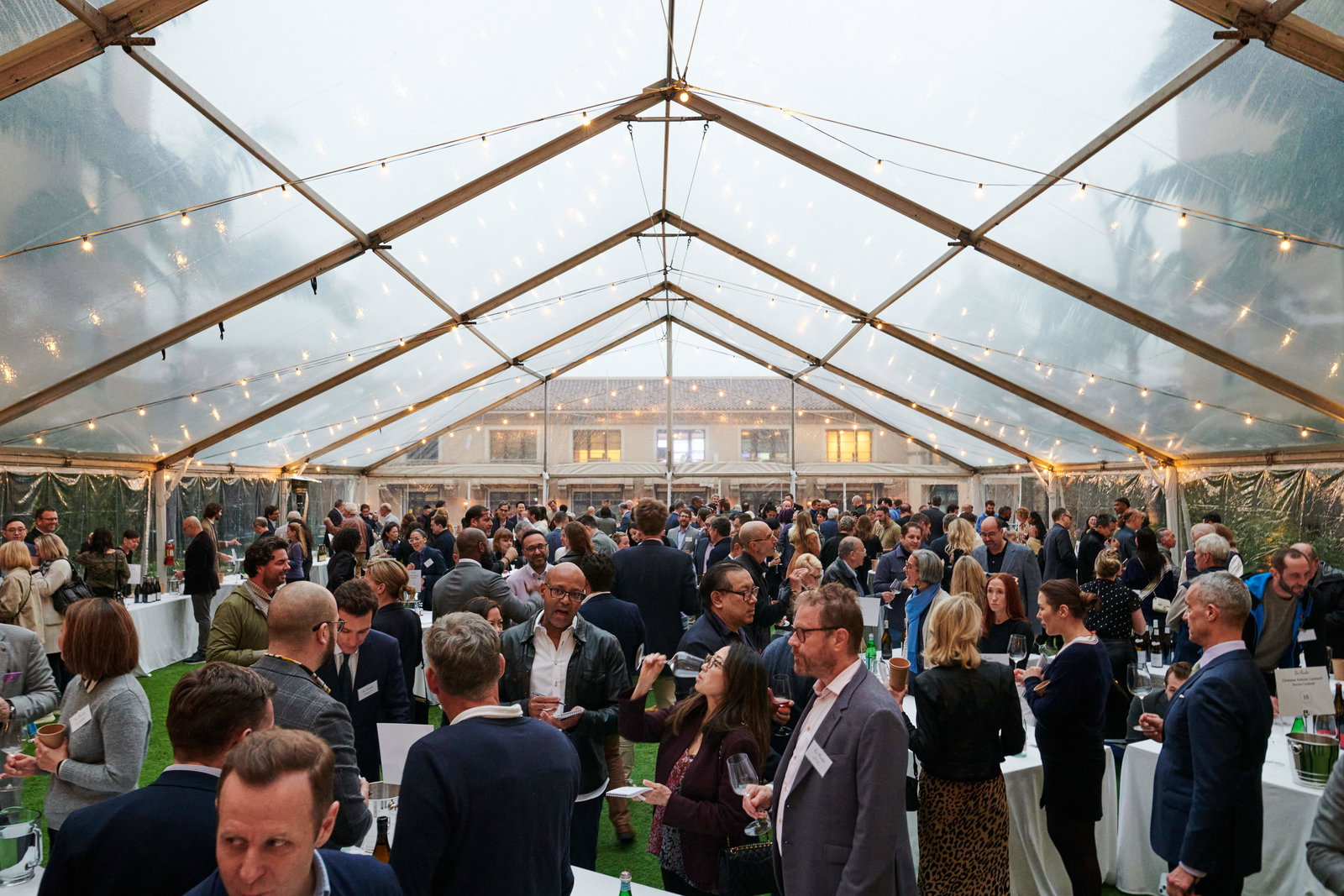 People gather and drink wine on a covered rooftop at La Paulée Los Angeles