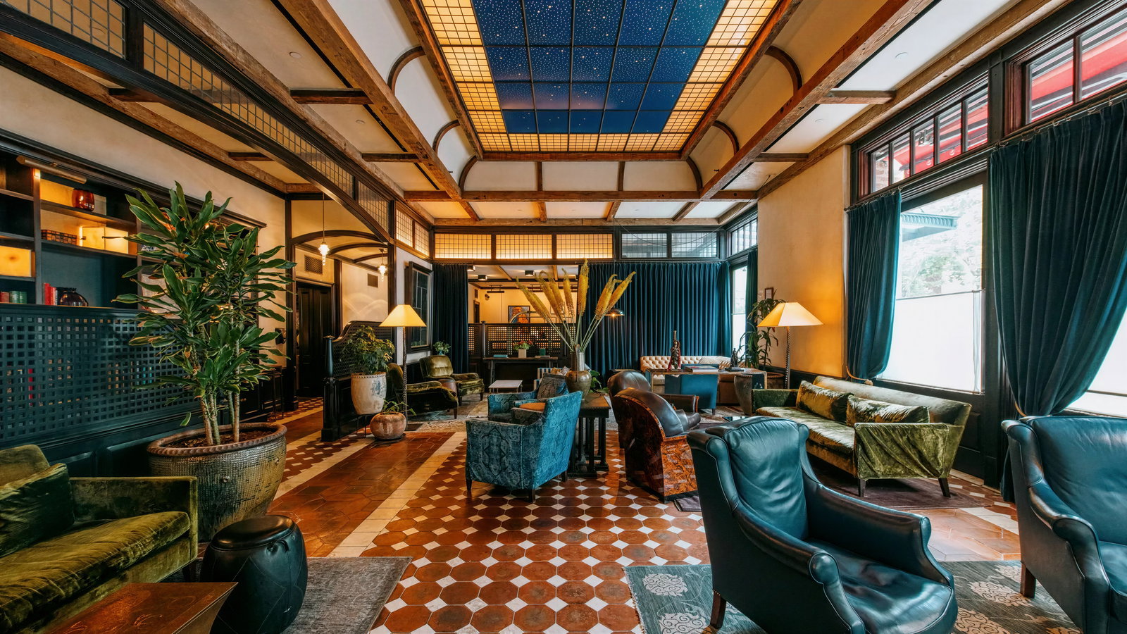 Luxurious lounge with vintage decor, velvet sofas, and patterned tiles. Blue drapes and starry ceiling create an elegant, cozy ambiance.