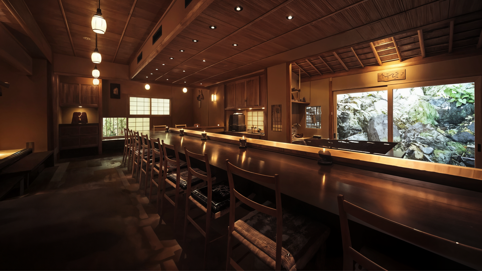 Warm, dimly lit Japanese restaurant interior with wooden decor, an empty counter, and chairs. Large window shows lush greenery outside. Cozy ambiance.