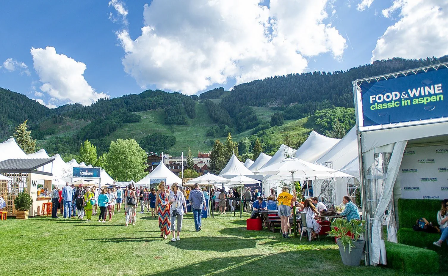 Beautiful rolling green hills and white tents on a sunny day at the Aspen Food & Wine Classic