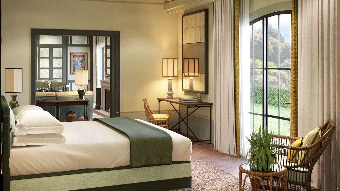 Elegant bedroom with a green-accented bed, wicker chair, and a desk under a lamp. Large window with curtains showing a garden view. Cozy ambiance.