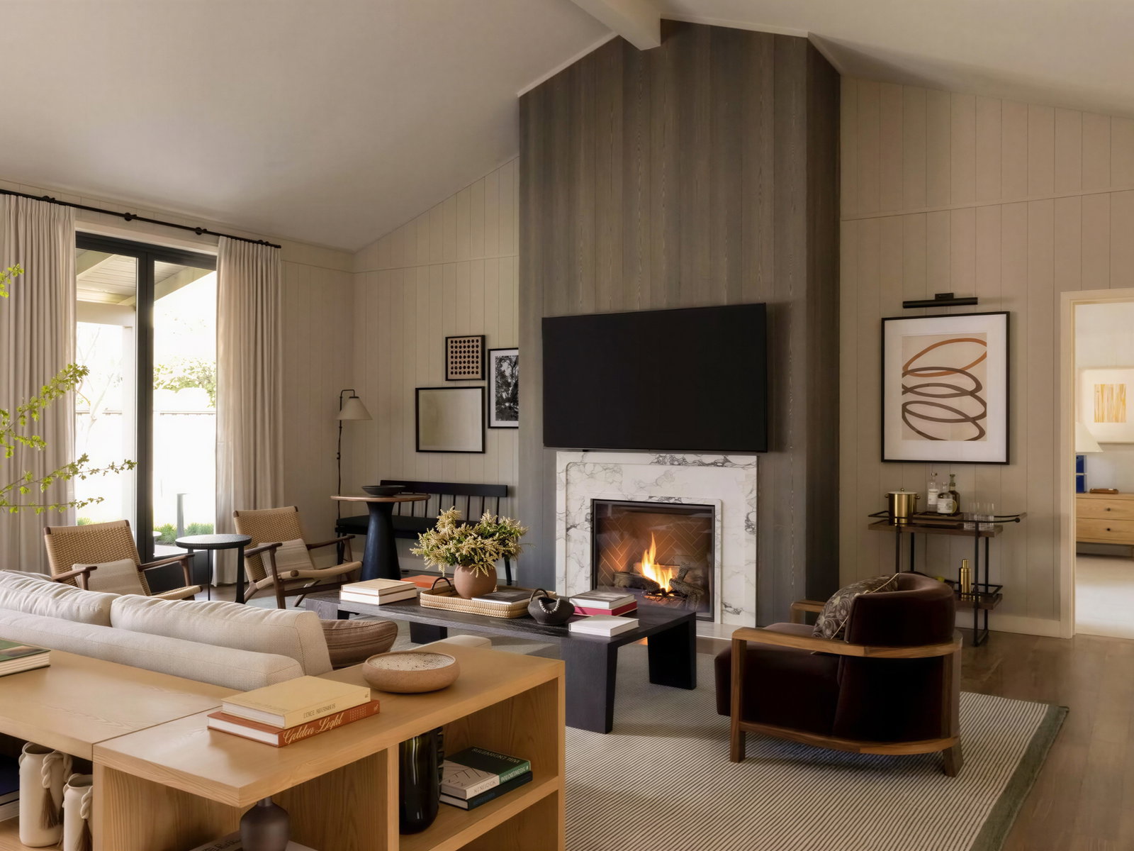 Cozy living room with a modern fireplace, beige sofa, and armchairs. Neutral tones, abstract art, and natural light create a calming ambiance.