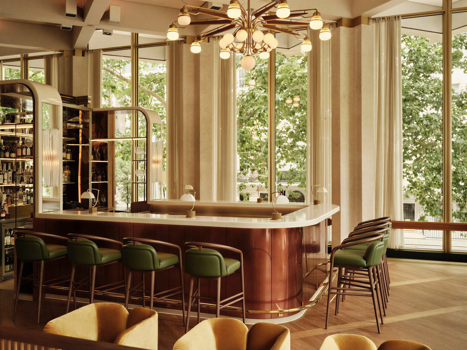 Elegant bar of The Chancery Rosewood with green stools and a curved counter, set in a bright space with large windows and leafy trees outside. Retro chandelier above.