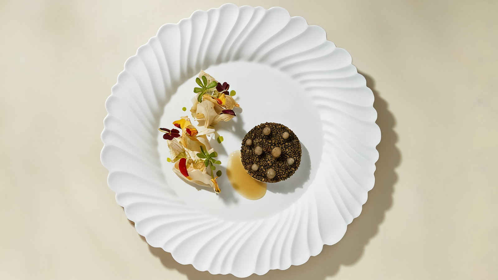Gourmet dish on a white, textured plate: a black round food item, colorful garnishes and sauce. Beige background, elegant presentation.