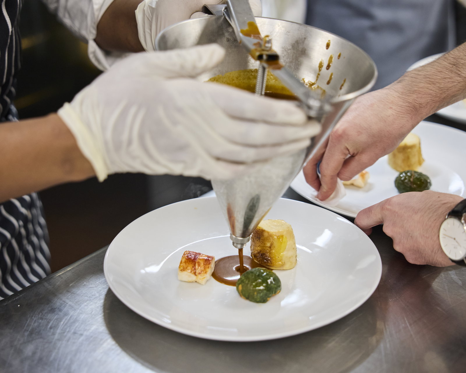 A chef prepares a scallop dish at La Fete 2024. Photo courtesy of @Jamescfrench