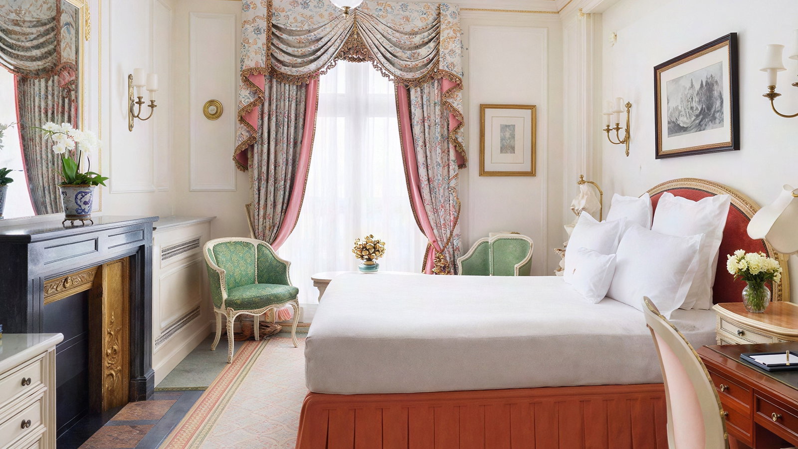 Elegant bedroom with a large bed, ornate curtains, vintage chairs, fireplace, and floral decor. Soft colors; luxurious and serene atmosphere.