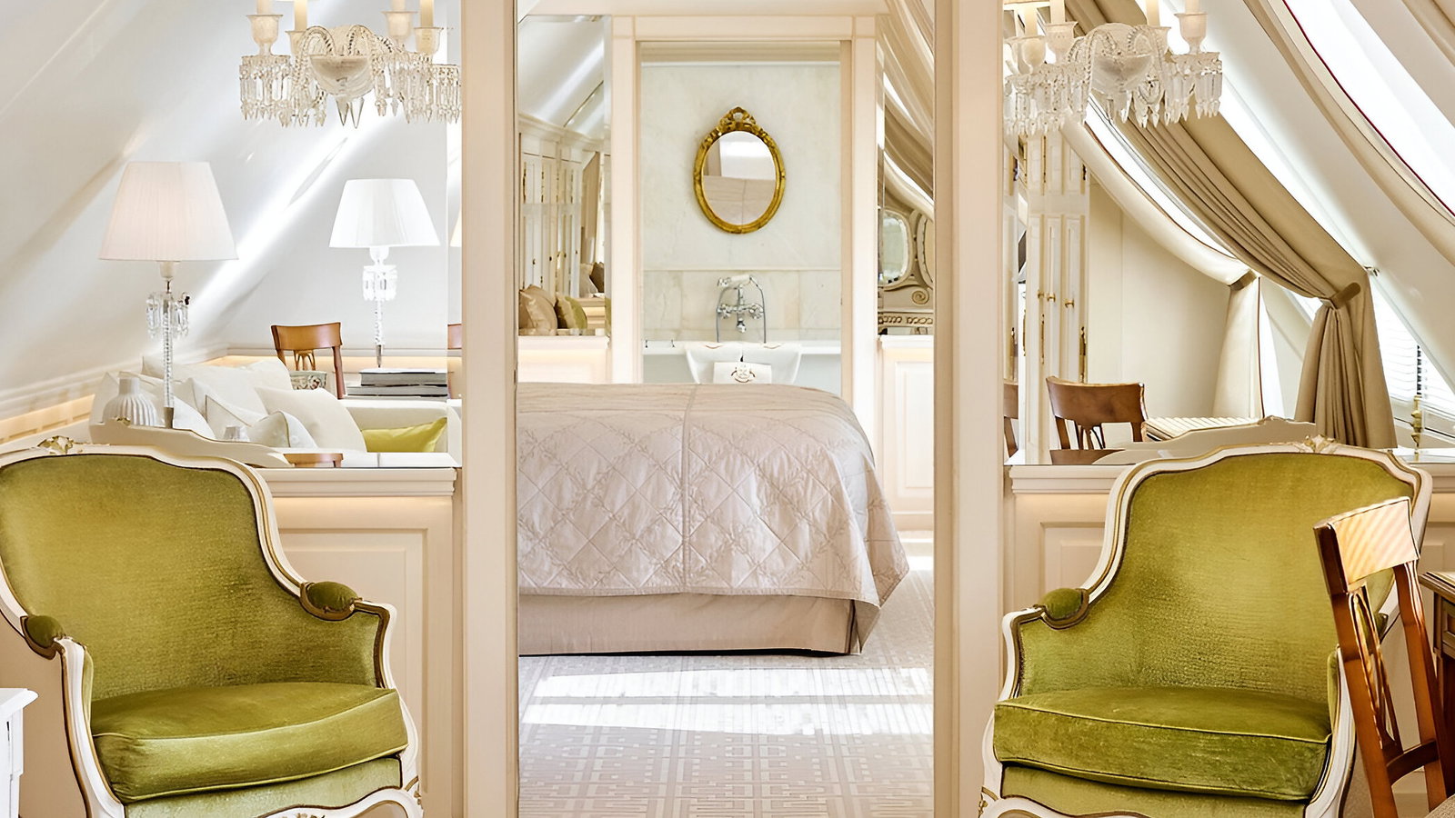 Elegant attic bedroom with green armchairs, a bed, and a round mirror. Soft lighting and beige curtains create a cozy, luxurious atmosphere.