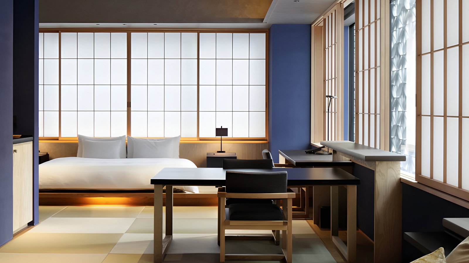 Modern room with a bed, desk, and chair. Soft lighting and sliding shoji screens. Neutral colors, minimalist design, calm ambiance.