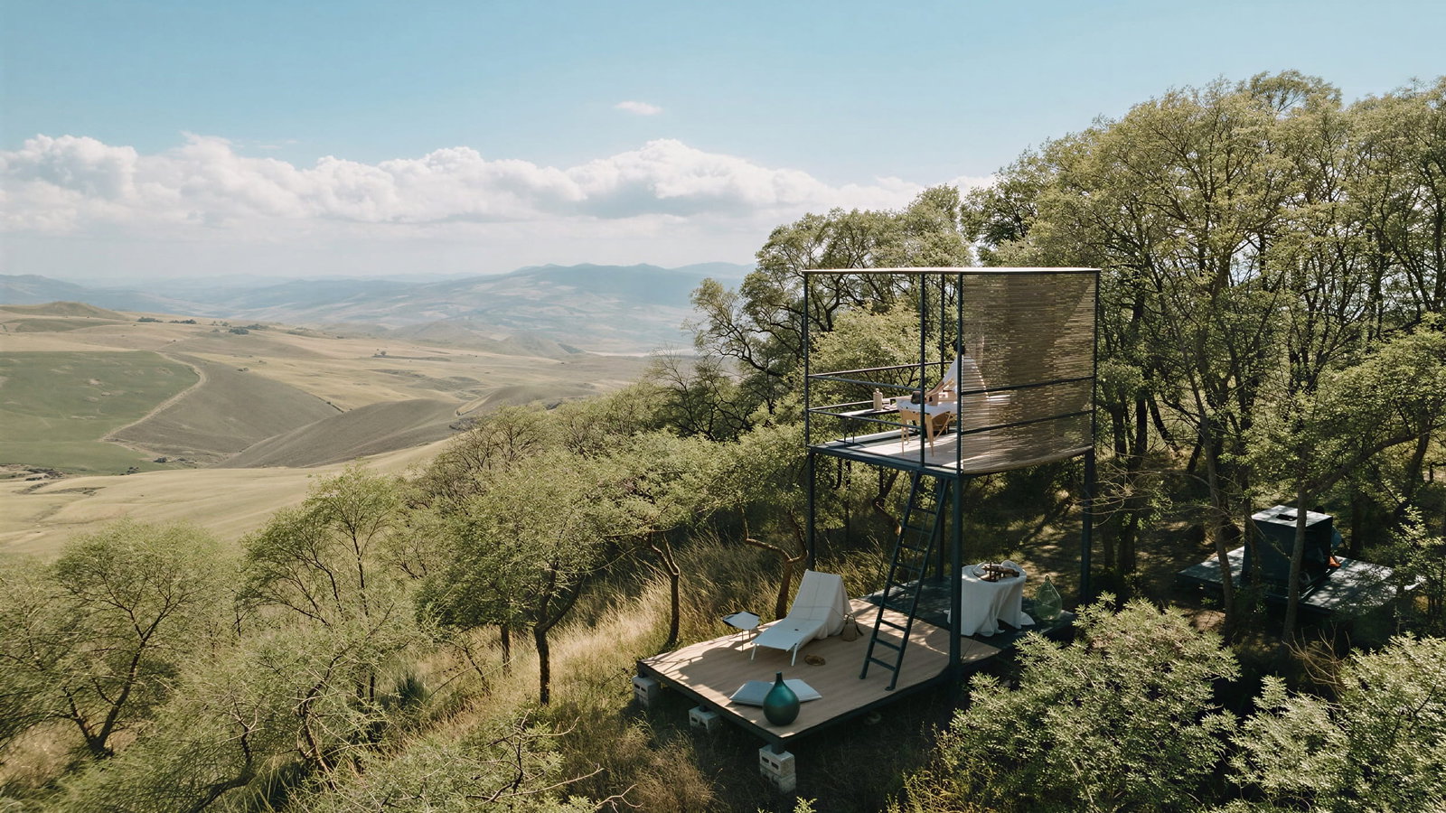 Picnic in the mountains at Masseria Susafa. Modern treehouse with lounge chairs and table in lush hills under a clear blue sky. Calm, scenic view with scattered trees and mountains.