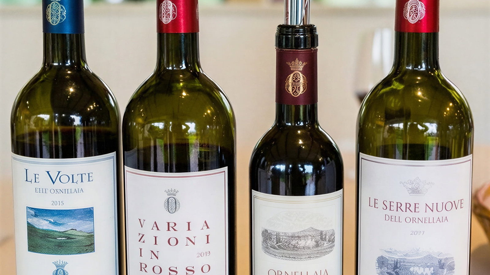 Four tasting wine bottles at Ornellaia Winery with pourers on a table, each labeled: Le Volte 2015, Variazioni in Rosso 2013, Ornellaia 2010, Le Serre Nuove 2007.