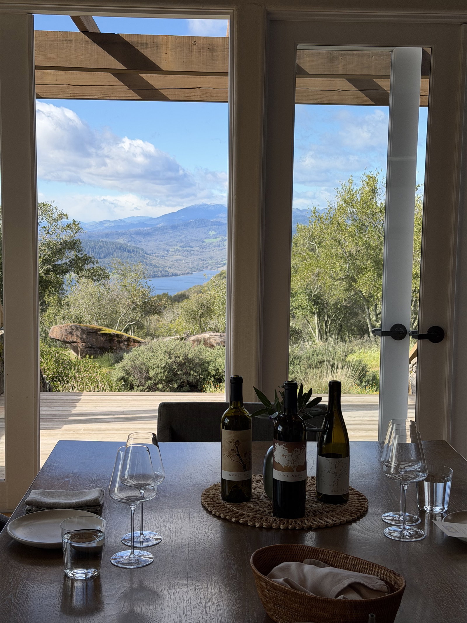 Continuum Estate tasting lineup on a table with mountain views through open doors