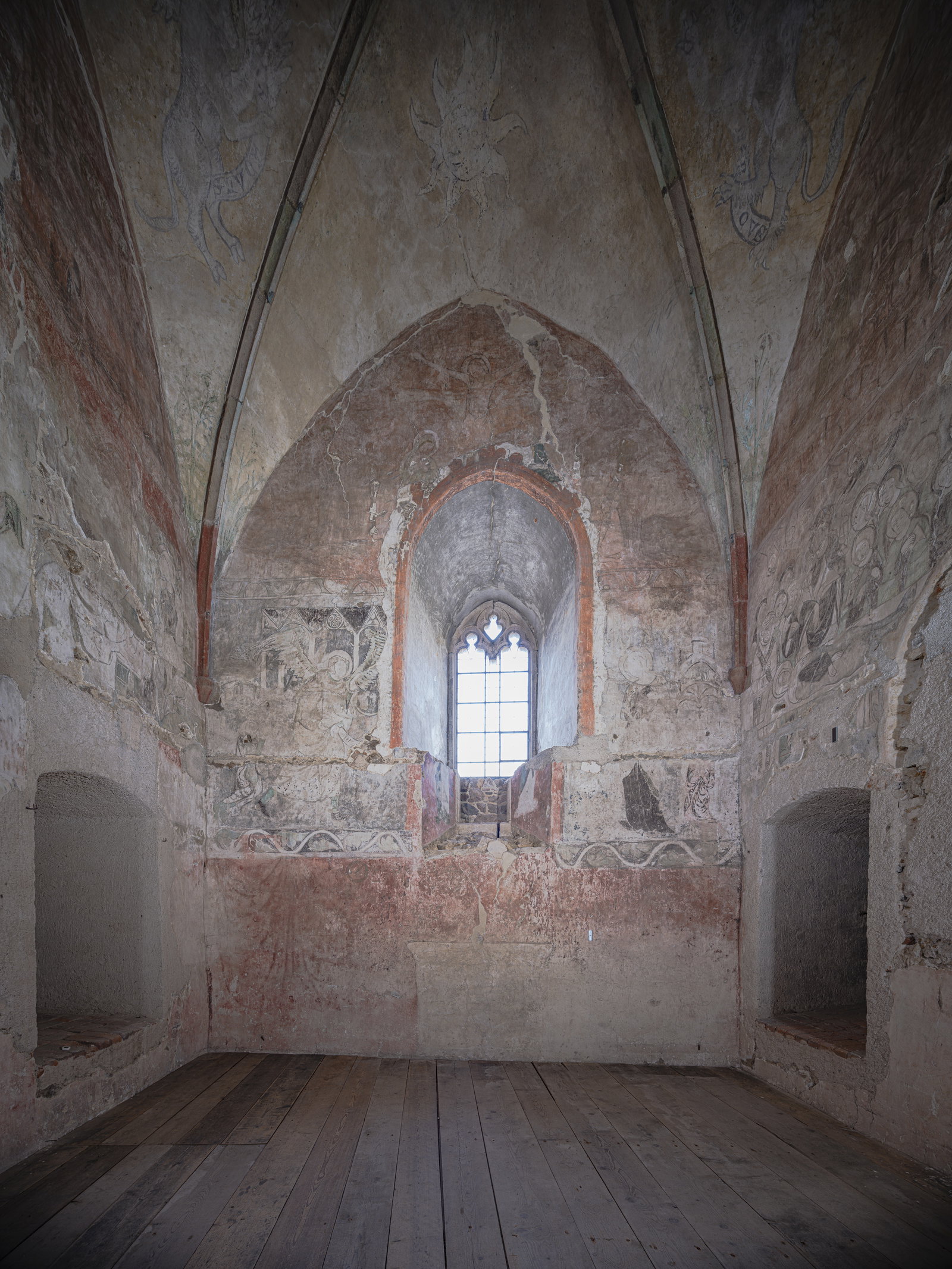 Gothic vaulted stone interior at Bečov Castle with faded frescoes and a narrow window, photographed by Martin Frouz.