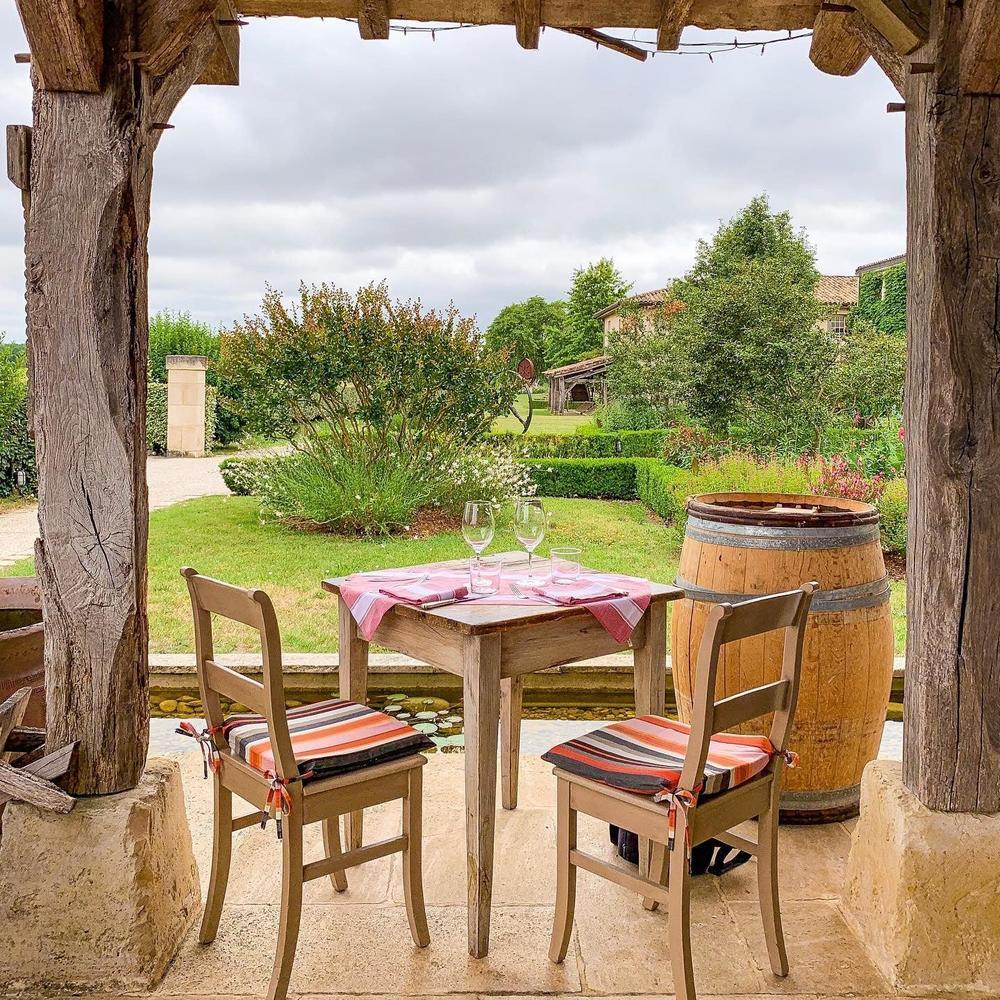 Terrace table at La Table du Lavoir surrounded by gardens