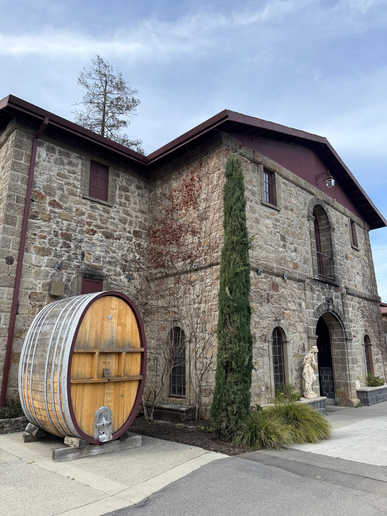 Historic Cathiard Vineyard stone winery with a large oak barrel outside